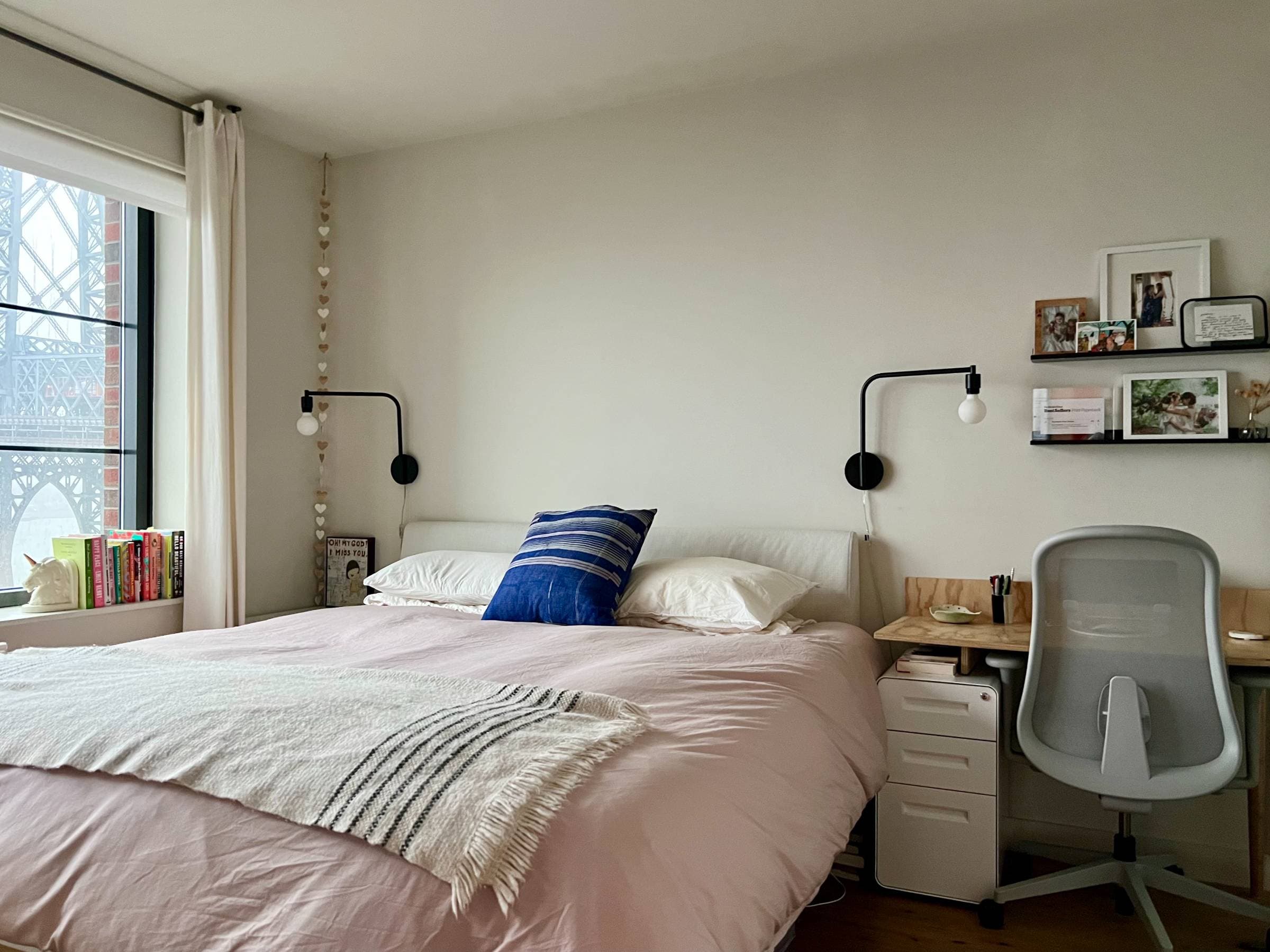 The primary bedroom has a king bed, Parachute linens, and a small WFH desk with Herman Miller chair. The primary bedroom has an en suite bathroom. 